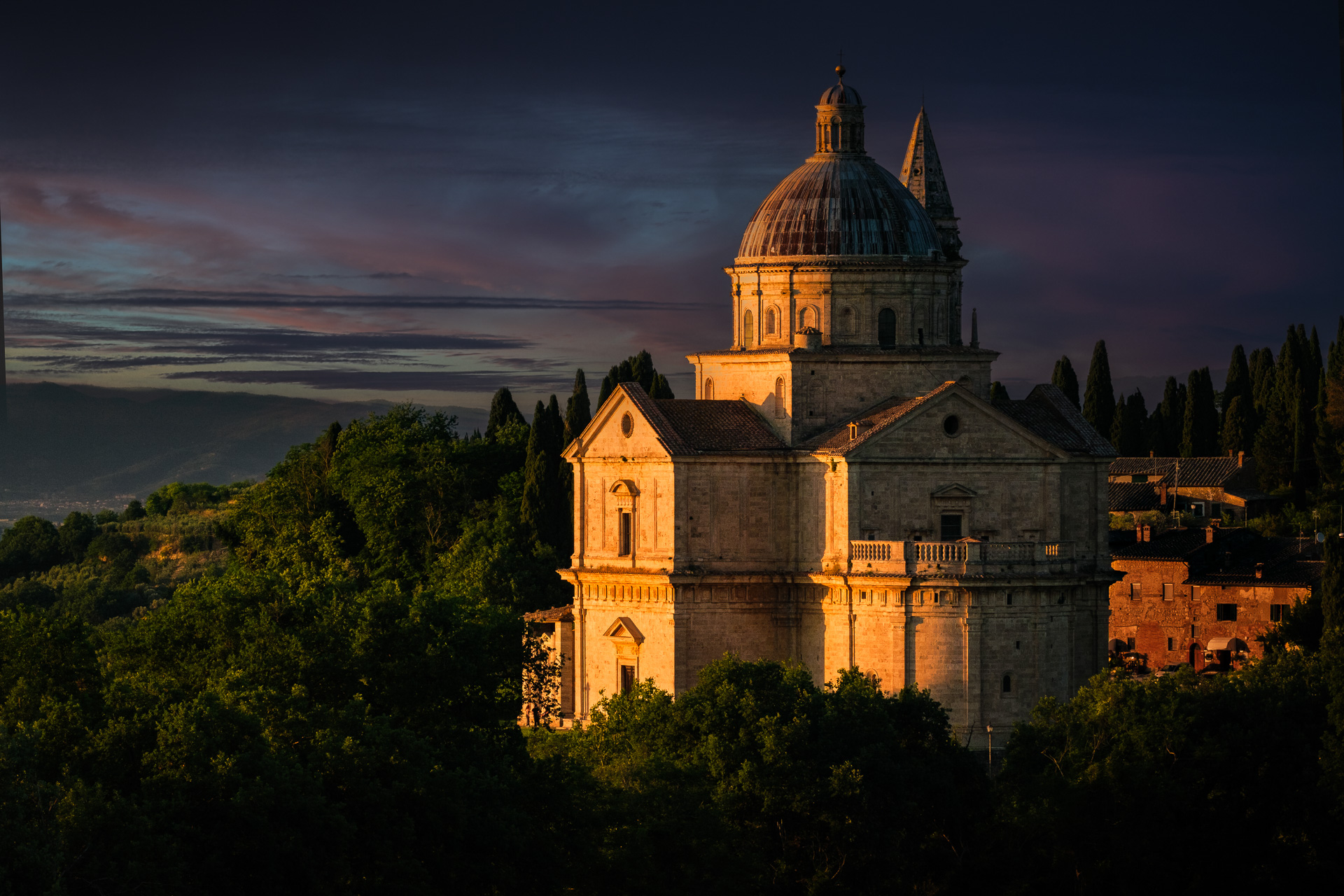 Sunset view of domed church and countryside.