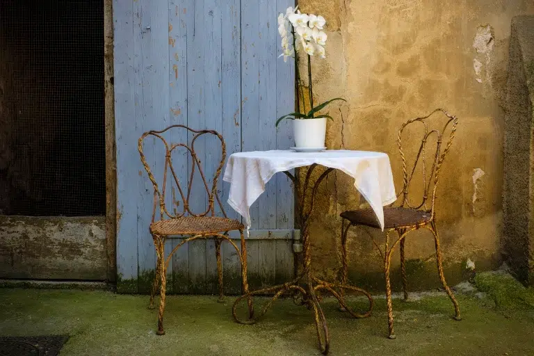 Rustic patio table with two metal chairs in Lourmarin France