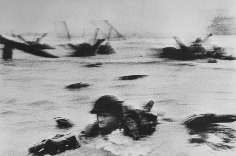 Soldier crawling through surf during on Omaha Beach during D-Day, World War II.